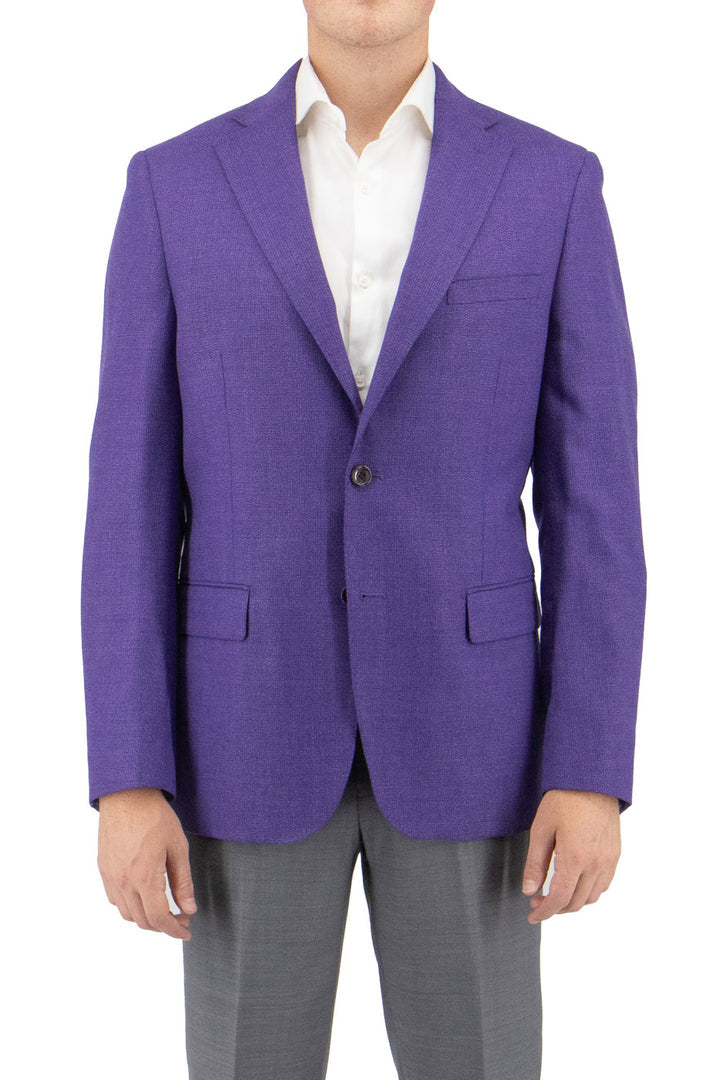 A person is impeccably dressed in men's clothing, wearing a Tiglio Luxe Violet Dolcetto/THP Modern Fit Half Lined, Pure Wool Jacket TL2735 over a white shirt and gray pants, showcasing sartorial traditions at their best.