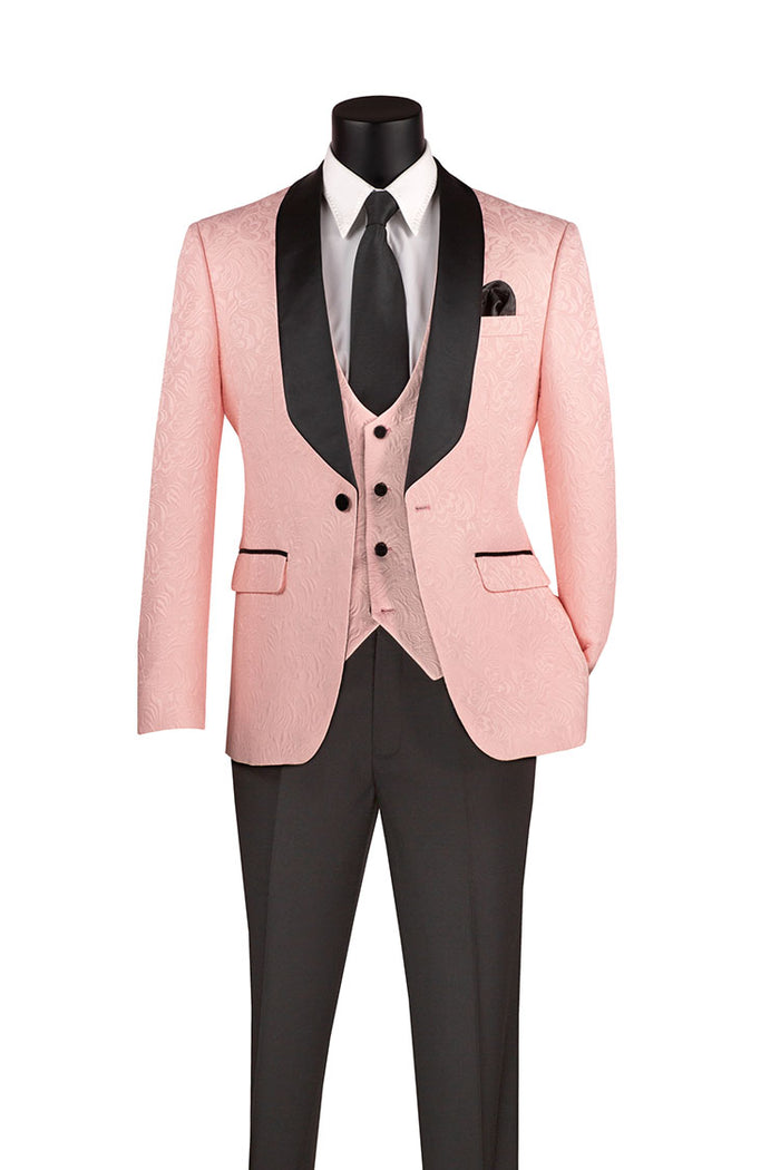 Displayed on the mannequin is the Vinci Suits ensemble: a pink slim fit tuxedo jacket with black lapels, paired with a pink vest and sleek black trousers, all made from jacquard fabric for an elegant touch. The look is completed with a white shirt and black tie. This stylish set is identified as the Vinci Slim Fit 3 Piece Single Button Jacquard Fabric Tuxedo Pink TVSJ-1.