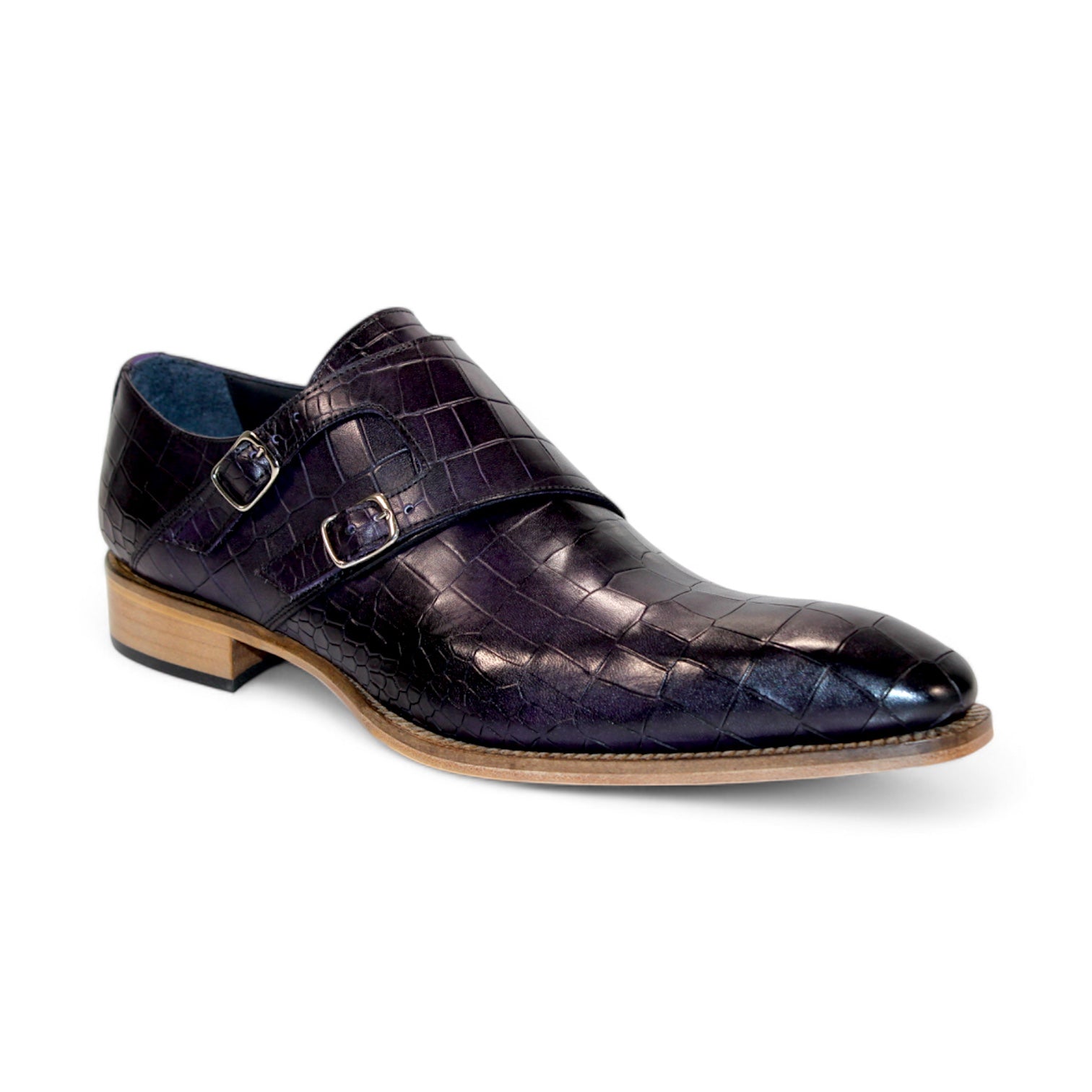 The Duca Di Matiste Vergato in purple is a single dark embossed leather monk strap shoe featuring double buckles and a light wooden sole, elegantly displayed on a white background. Made in Italy by Duca Di Matiste, this exquisite footwear exemplifies impeccable craftsmanship and material quality.