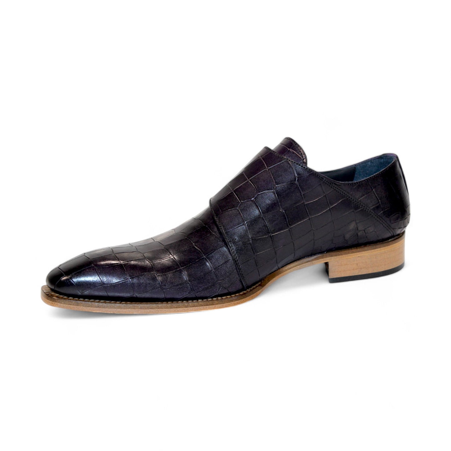 The Duca Di Matiste Vergato in purple is a single dark embossed leather monk strap shoe featuring double buckles and a light wooden sole, elegantly displayed on a white background. Made in Italy by Duca Di Matiste, this exquisite footwear exemplifies impeccable craftsmanship and material quality.