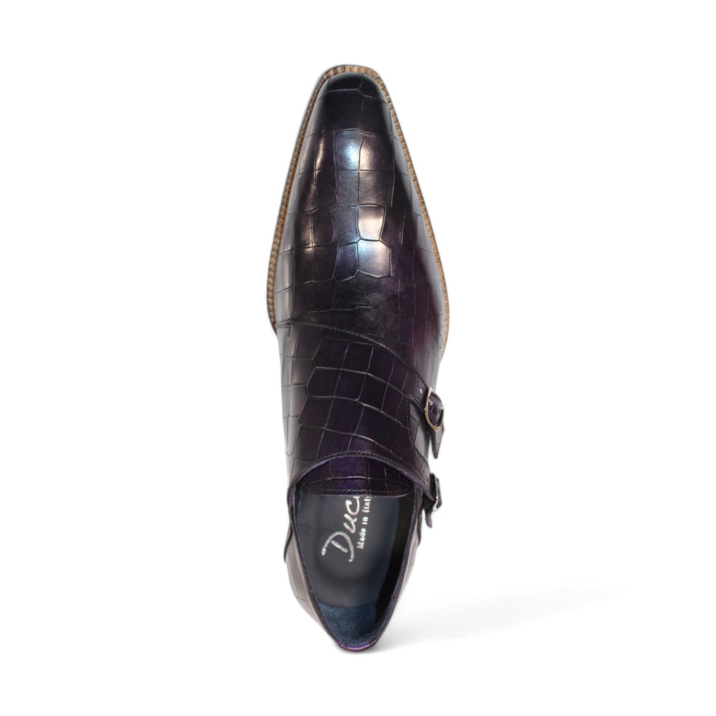 The Duca Di Matiste Vergato in purple is a single dark embossed leather monk strap shoe featuring double buckles and a light wooden sole, elegantly displayed on a white background. Made in Italy by Duca Di Matiste, this exquisite footwear exemplifies impeccable craftsmanship and material quality.