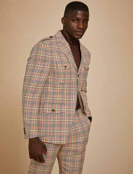 Against a plain background, a person poses in the Inserch 4 Pocket Houndstooth Micro Check Suit BL265-64 Mocha, featuring a modern fit and paired with a brown shirt, offering a glimpse of the print lining.