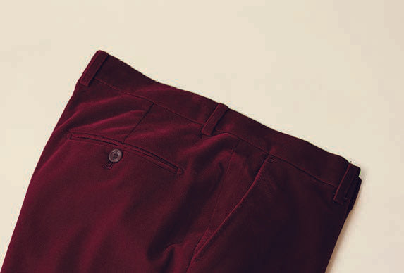 The Inserch Velvet Pants P502-31 in Burgundy, crafted from a velvet poly nylon blend, are folded neatly on a flat surface. They showcase a modern fit with a stylish flat front chino design and feature a back pocket with a button.