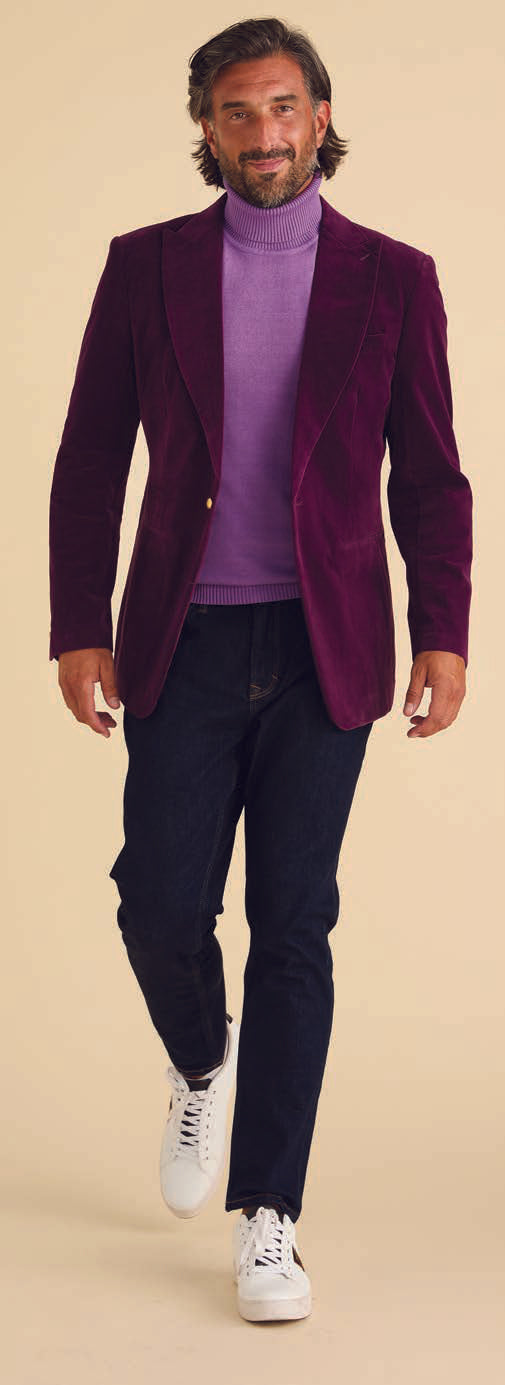 A man in a deep violet Inserch Velvet Blazer (BL007-166) with jacquard lining, dark jeans, and white sneakers walks confidently against a beige background.