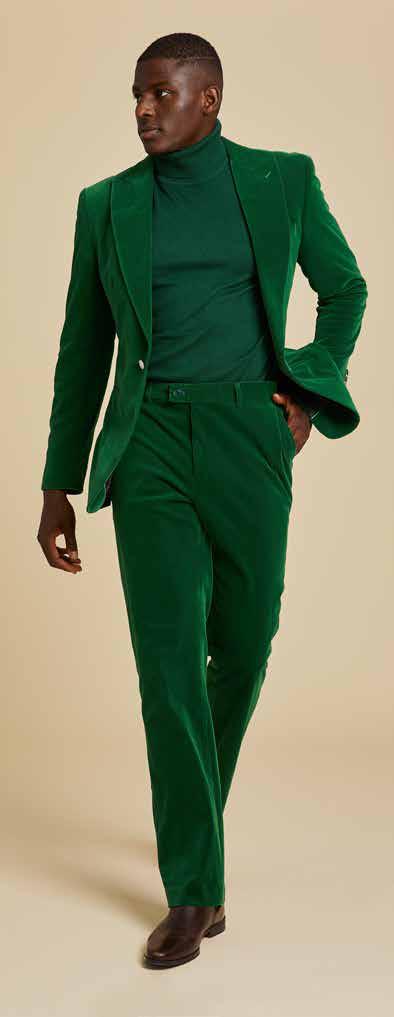 Clad in the Inserch Single Breasted Peak Lapel Velvet Suit BL007-201 Green Sapphire, a person strides confidently against a beige background, radiating modern elegance.