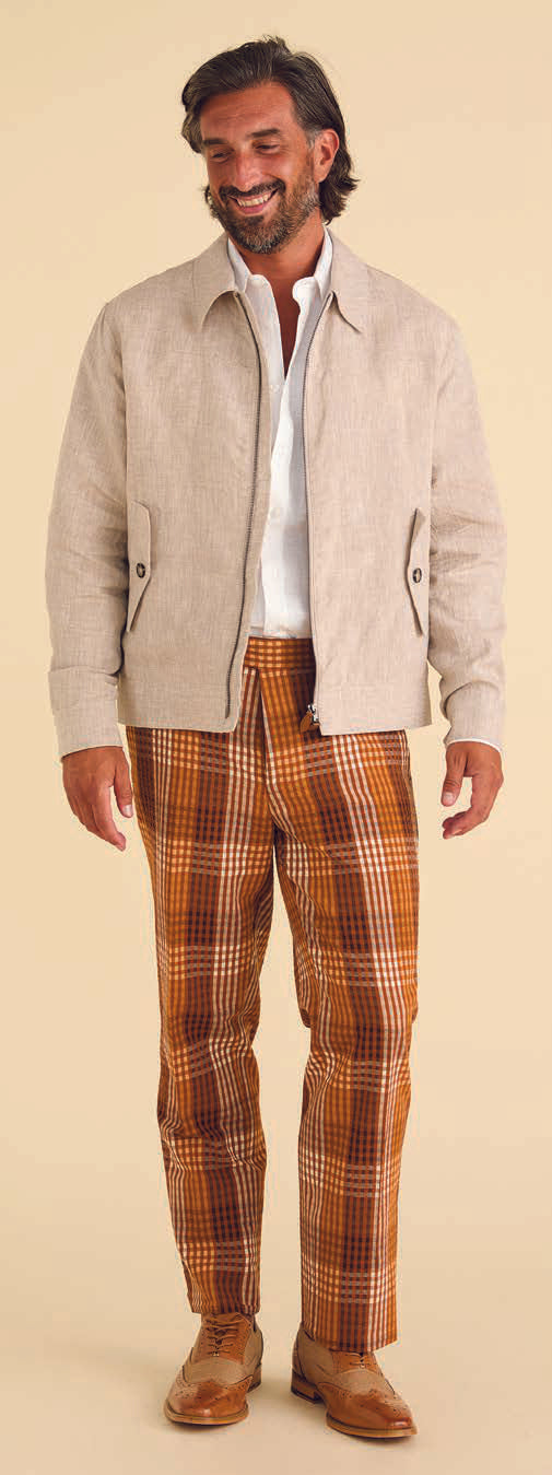 Dressed in Inserch's Seersucker Gingham Pants P272-00027 Aztec, paired with brown brogues, a person stands against a beige background, flawlessly embodying modern style with touches of premium cotton.