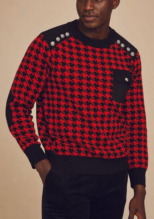 A person wearing the Inserch Cotton Blend Houndstooth Crew Neck Sweater in red, featuring a military-inspired design with black shoulder details and a pocket.