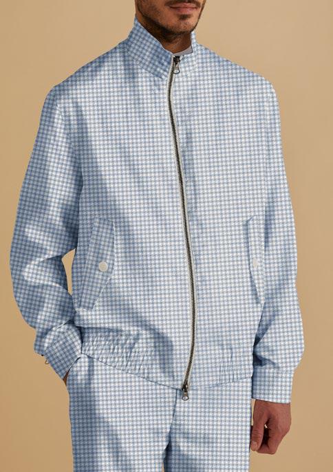 An individual stands against a beige background, donning the Inserch Linen Houndstooth Jacket Suit JS269-00014 Lt. Blue, featuring a tailored design with a blue and white checkered pattern and zipper.