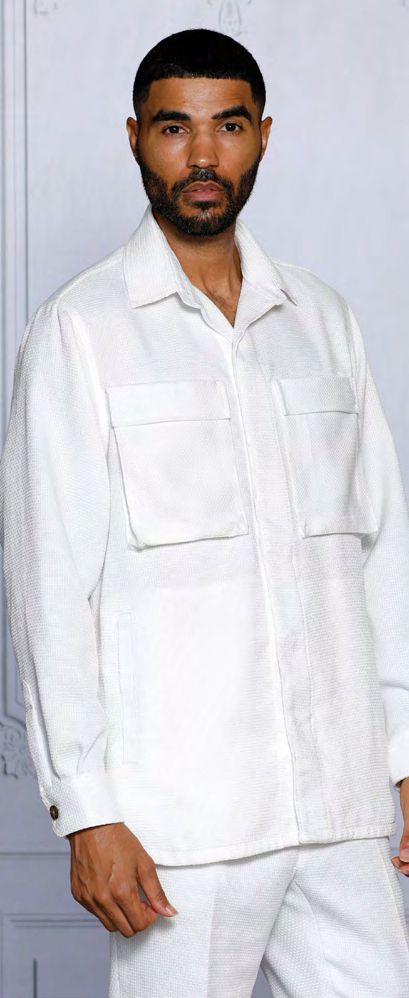 A man dressed in an INSOMNIA CAVALLI 2PC White Leisure Suit by Insomnia, featuring a textured jacket with large front pockets, is standing against a light-colored background.