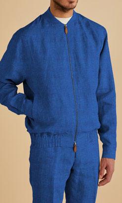 A person in the Inserch Linen Bomber Jacket Suit JS660-00181 River Blue, featuring a classic ribbed collar and matching premium linen pants, stands against a beige background with their face not visible.