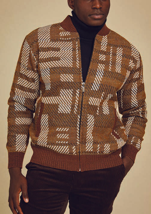 A man wears the Inserch Geometric Full Zip Baseball Knit Jacket SW609-27 Aztec over a black turtleneck, paired with brown pants.