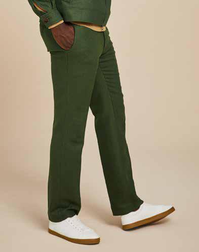 A person is wearing Inserch's Herringbone Pants P263-19 Olive paired with white sneakers against a beige background.