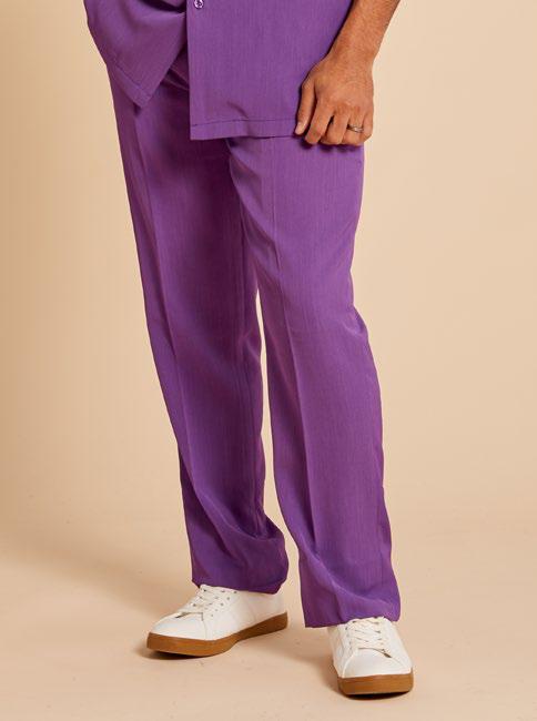 A person is shown wearing Inserch Crepe Flat Front Pants P9356 in a tailored purple style, made from poly-crepe fabric. They are paired with a matching top against a beige background and completed with white sneakers to achieve a chic and regular-fit style. Only the lower half of their body is visible.