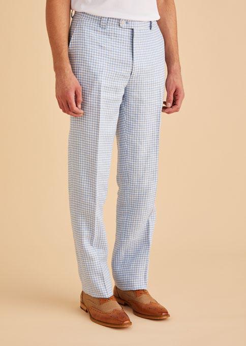 A person dressed in Inserch Linen Houndstooth Pants P269-00014 in light blue and brown dress shoes poses against a beige background, showcasing subtle sophistication with a touch of premium linen texture.