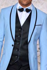 A person dressed in the Insomnia INSOMNIA SUNSET 3PC Slim Fit Sky Black Tuxedo Suit, featuring a light blue jacket with black trim, a reversible vest, a crisp white shirt, and a sharp black bow tie.