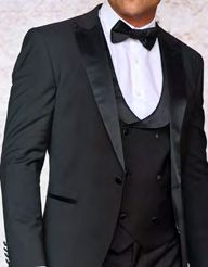 A man wearing the Insomnia Rome 3PC Slim Fit Black Spandex Tuxedo Suit, paired with a bow tie and white shirt.