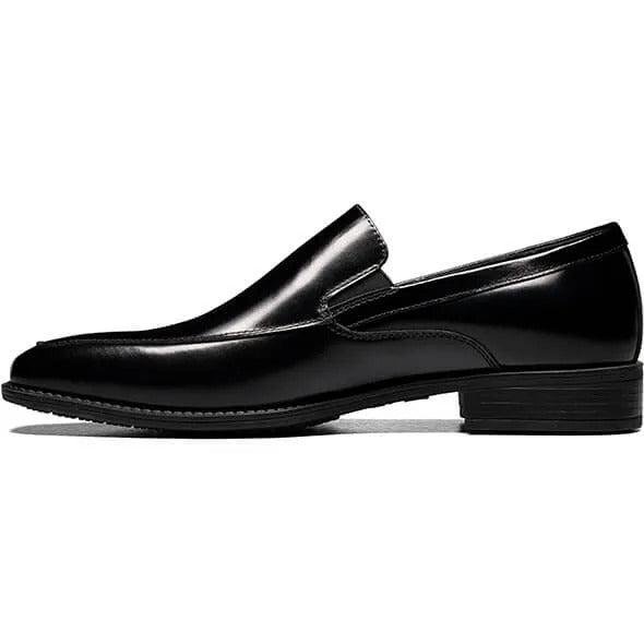 The Stacy Adams ALDRICH Moc Toe Slip On (style number 20193-001) features a sleek black leather upper and a cushioned insole, presented on a white background.