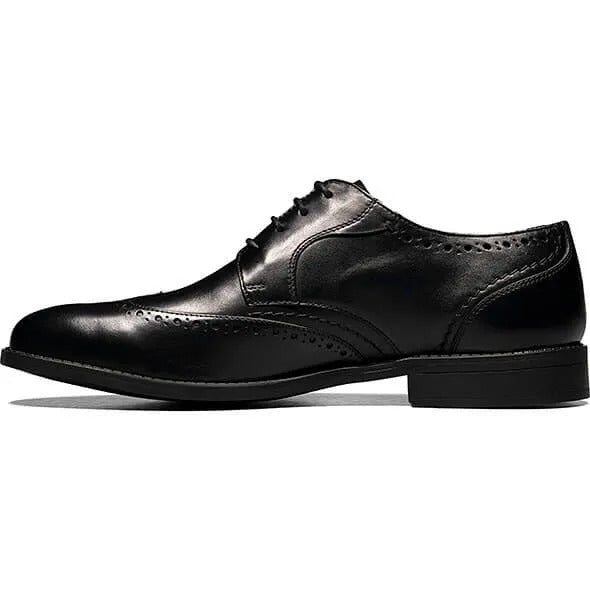 The Stacy Adams Barlow Wingtip Oxford in black, style number 20197-001, is crafted from burnished leather featuring brogue detailing and a lace-up design. It offers ultimate comfort with its Memory Foam footbed.