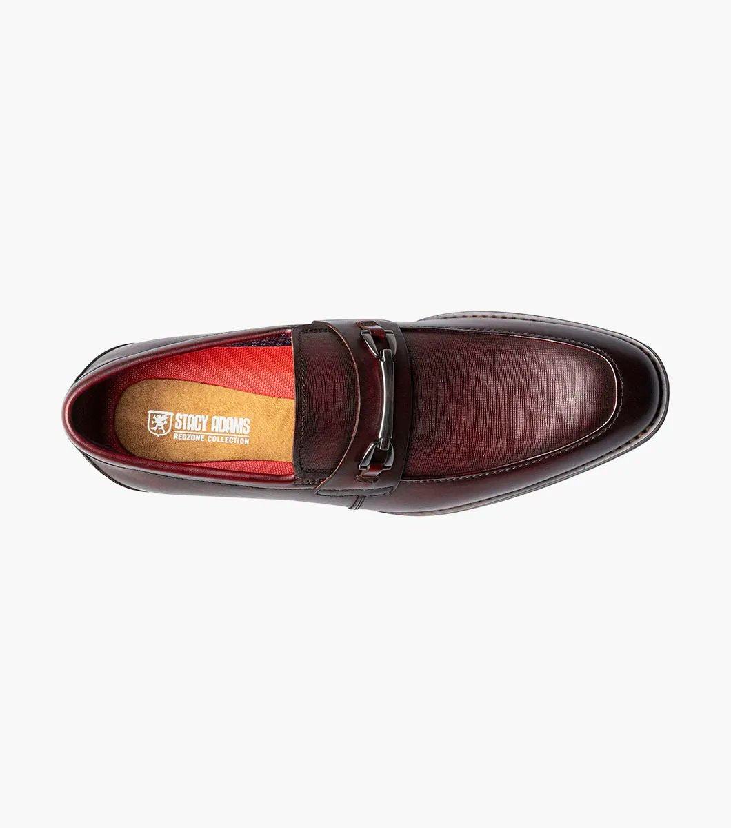 The Stacy Adams KAYLOR Moc Toe Bit Slip On in Burgundy, product number 25572-601, features a metal buckle detail, leather upper, low heel, and dark sole set against a plain white background.