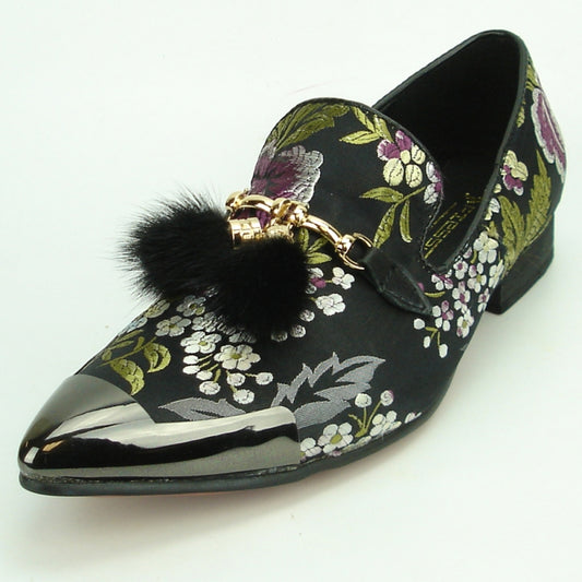 The FI-7250 Black Fiesso by Aurelio Garcia, from the brand Fiesso, boasts a sophisticated black floral-patterned suede upper complemented by a shiny toe. It is elegantly adorned with a gold chain and features chic black pom-pom embellishments. For added comfort, this fashion shoe is equipped with a cushioned insole, ensuring it is as comfortable as it is stylish.