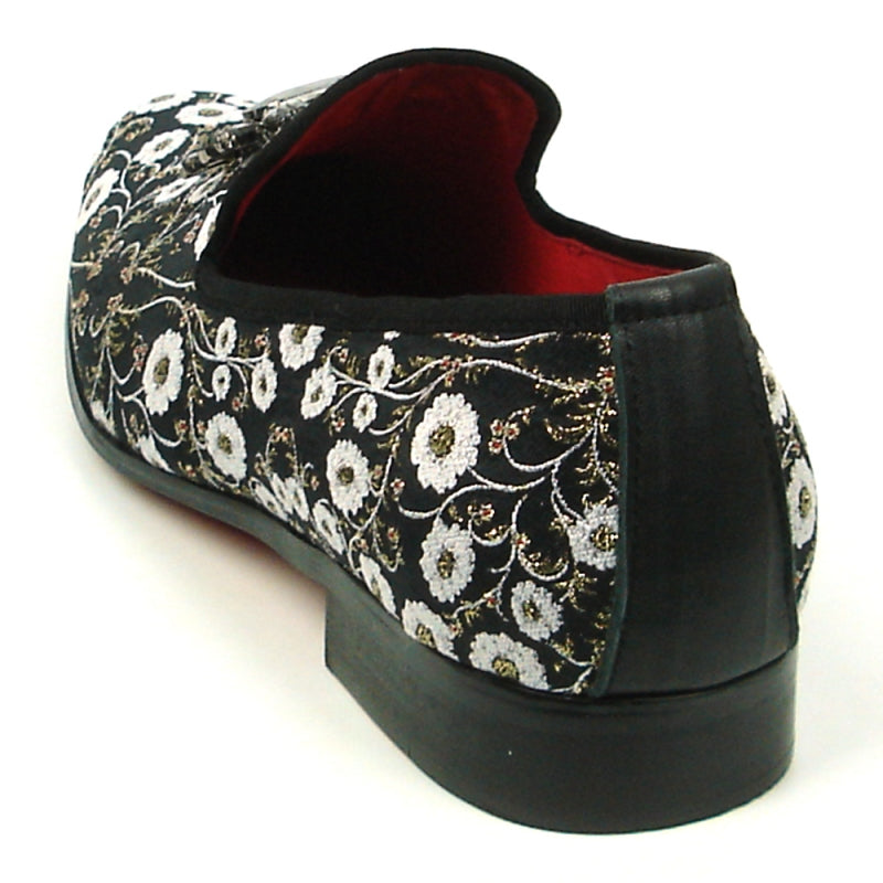 The FI-7386 Black Flowers Slip-on by Fiesso features ornate white floral embroidery and a decorative jewel on top. With a luxurious red interior lining, cushioned insole, and black sole, this stylish slip-on from Fiesso by Aurelio Garcia combines comfort with elegance effortlessly.