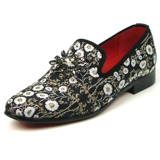 The FI-7386 Black Flowers Slip-on by Fiesso features ornate white floral embroidery and a decorative jewel on top. With a luxurious red interior lining, cushioned insole, and black sole, this stylish slip-on from Fiesso by Aurelio Garcia combines comfort with elegance effortlessly.