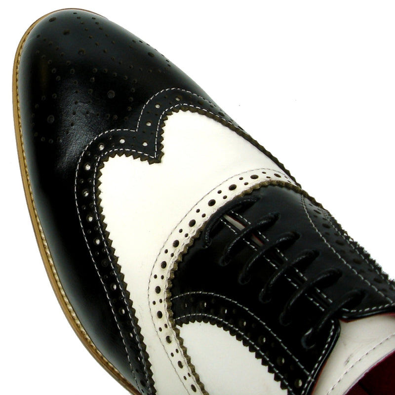 Fiesso introduces the FI-7400 Black White Wing Tip Lace Up by Aurelio Garcia, a striking fashion shoe with a leather upper adorned with intricate perforations and enhanced by a chic brown sole, all highlighted against a plain white background.