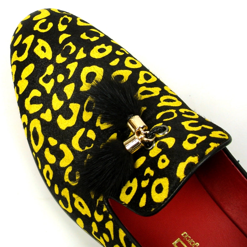 The FI-7402 Black Yellow Leopard Fiesso by Aurelio Garcia loafer from Fiesso showcases a leather upper in a striking yellow and black leopard print, complemented by a red interior and adorned with black tassels on top.