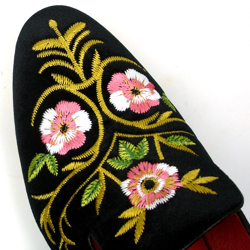 The FI-7409 Black Slip on by Fiesso showcases a luxurious black suede upper adorned with pink and yellow floral embroidery, complemented by a vibrant red interior lining. As part of the Fiesso by Aurelio Garcia collection, this loafer blends luxury with artistry for a truly standout style.