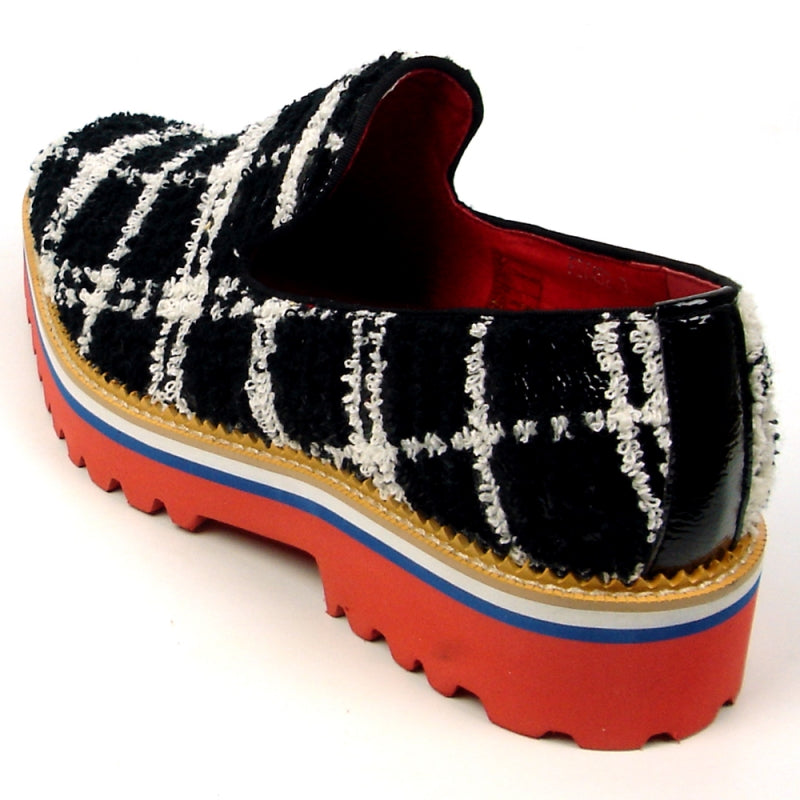 Introducing the FI-7452 Black Slip On by Fiesso, crafted by Aurelio Garcia, this stylish shoe showcases a striking black and white checkered fabric design with a vibrant red interior. It features a thick sole in bold shades of red, white, and blue. This comfortable slip-on design also includes a cushioned insole for enhanced comfort with every step.