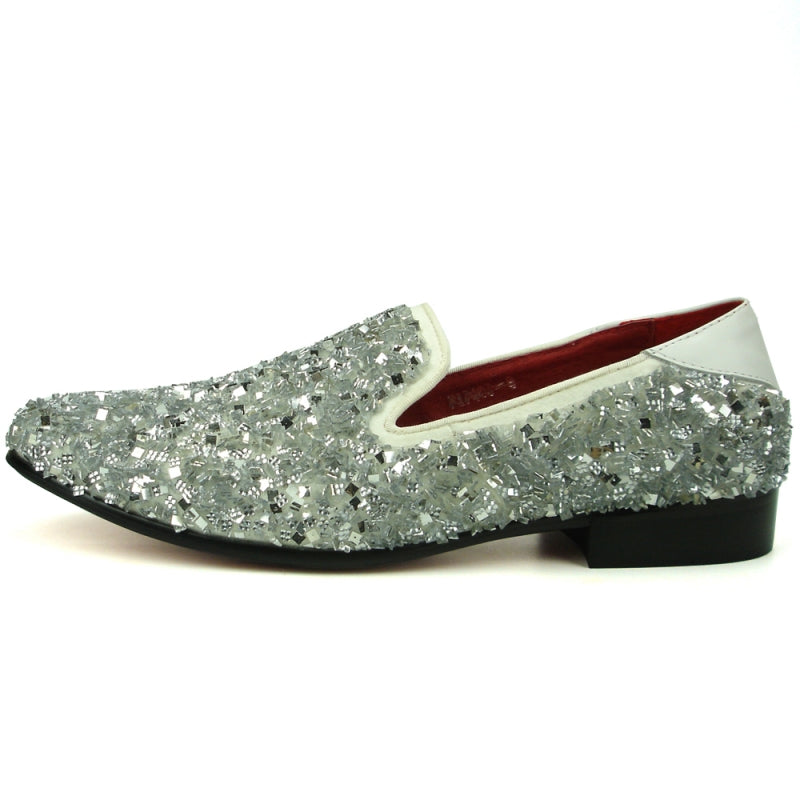 A single white slip-on shoe from the Fiesso by Aurelio Garcia collection, featuring a sleek design adorned with shiny beads, a black sole, and a luxurious red interior lining. Its textured crystals add a glamorous touch to the overall aesthetic.