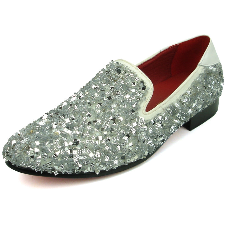 A single white slip-on shoe from the Fiesso by Aurelio Garcia collection, featuring a sleek design adorned with shiny beads, a black sole, and a luxurious red interior lining. Its textured crystals add a glamorous touch to the overall aesthetic.