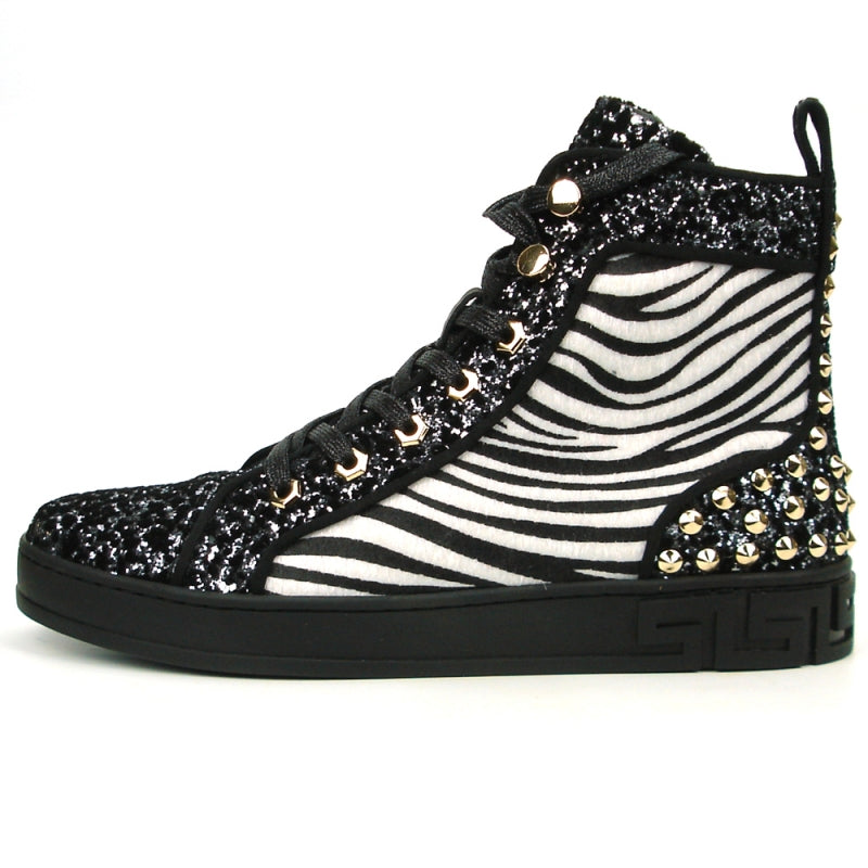 Introducing the FI-2347 Black-Zebra Black Sole High Top Sneakers Encore by Fiesso, these men's casual high-top sneakers showcase a striking black and white zebra pattern along with a glittery texture. Adorned with gold studs and black laces, they feature a leather upper. Designed for those who seek an edgy style, these sneakers are complete with bold spikes that make them stand out.