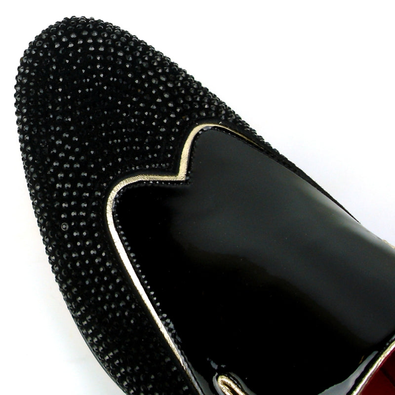 The FI-7483 Black Patent Wing Tip by Fiesso is a black fashion shoe with a patent leather upper and a red interior, featuring a glossy finish. It is elegantly adorned with small black beads and designed for comfort with its slip-on style and cushioned insole.