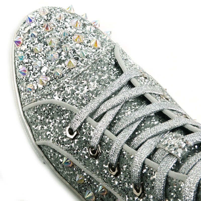 The FI-2409 Silver Glitter Black Spikes Encore by Fiesso is a striking high-top sneaker that shimmers with silver glitter and features eye-catching black spikes and rhinestones. It showcases a dazzling glitter upper, paired with fresh white laces and an immaculate white sole.