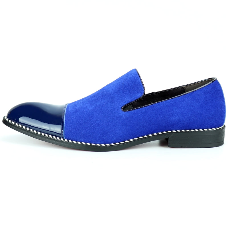 The Fiesso FI-7280 Blue Suede Cap Toe Slip On by Aurelio Garcia is a stylish shoe featuring a glossy patent leather toe cap and a sleek black sole.