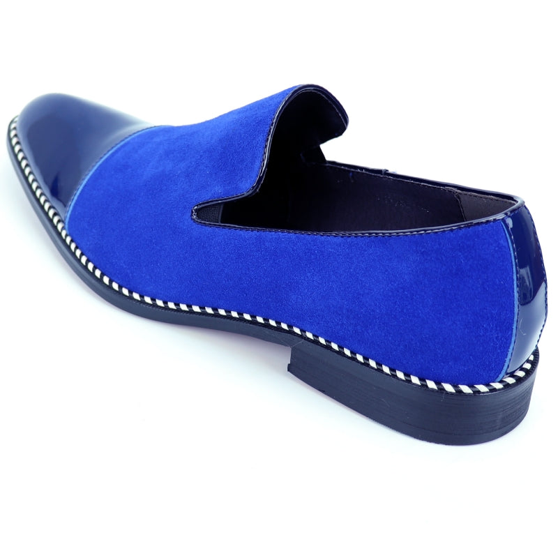 The Fiesso FI-7280 Blue Suede Cap Toe Slip On by Aurelio Garcia is a stylish shoe featuring a glossy patent leather toe cap and a sleek black sole.