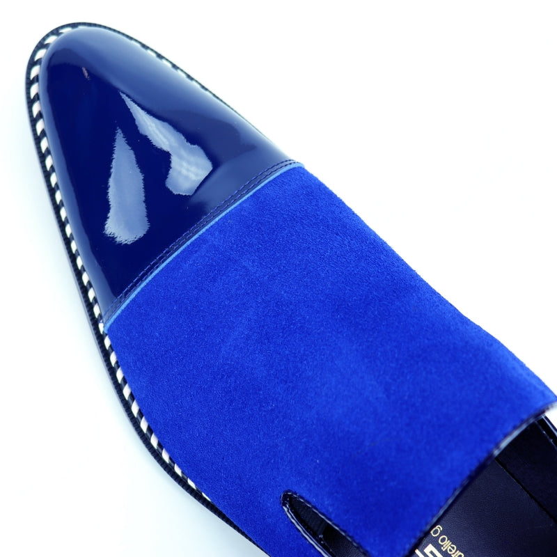 The Fiesso FI-7280 Blue Suede Cap Toe Slip On by Aurelio Garcia is a stylish shoe featuring a glossy patent leather toe cap and a sleek black sole.