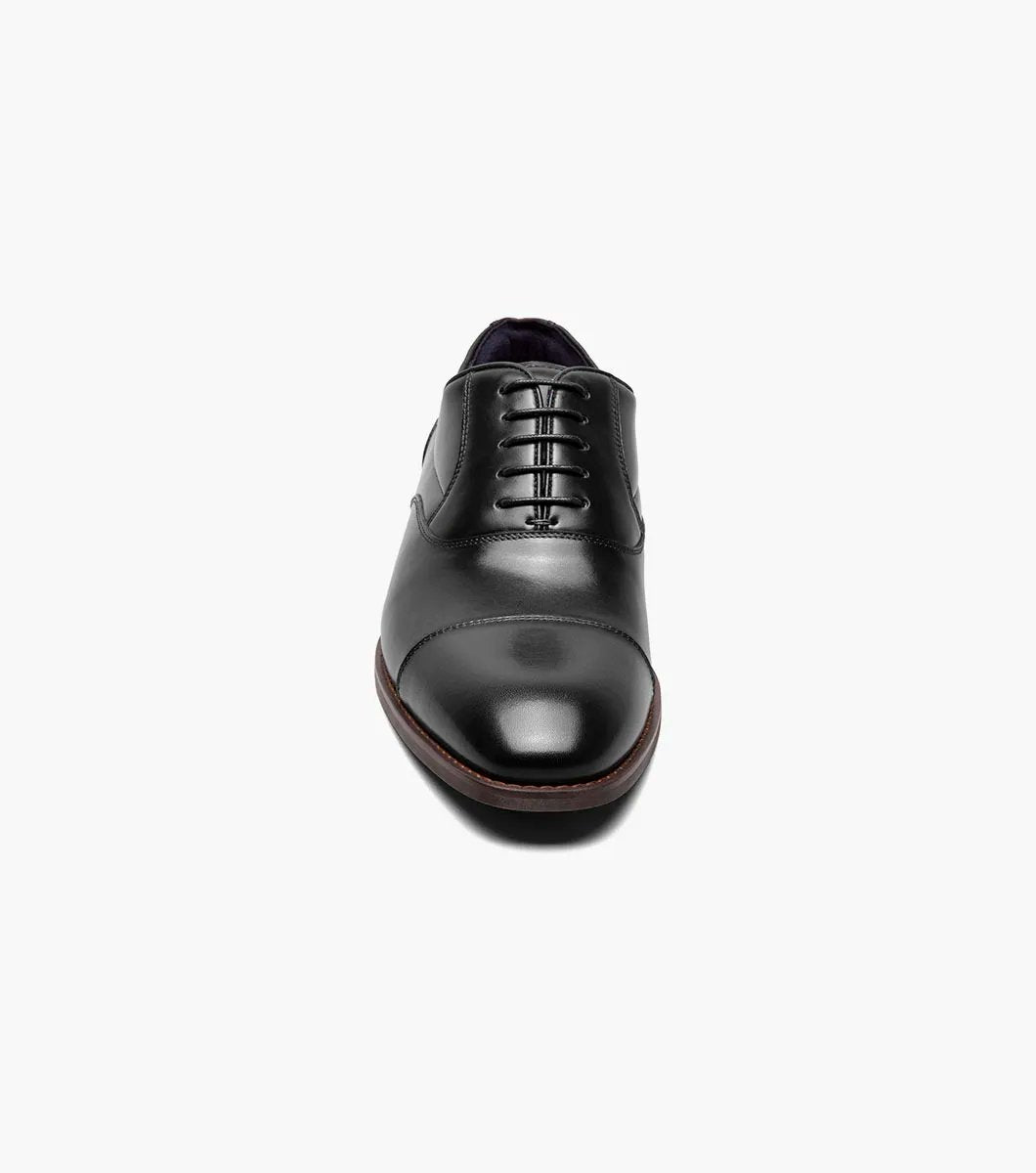 A side view of the Stacy Adams - KALLUM Cap Toe Oxford in black leather, featuring a burnished finish and a dark brown sole.