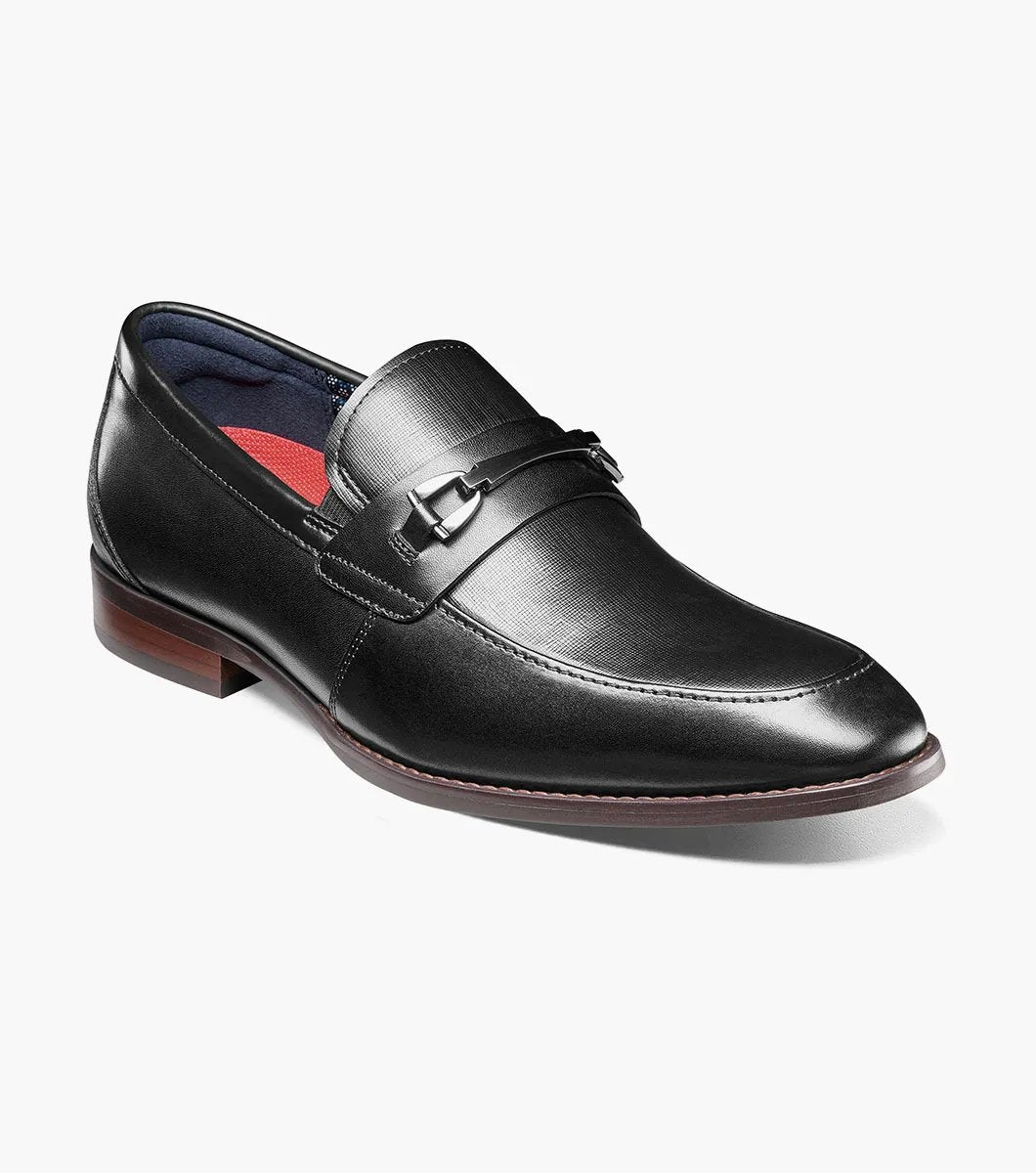 The Stacy Adams KAYLOR Moc Toe Bit Slip On in black (model 25572-001) is a sophisticated leather loafer from STACY ADAMS, highlighted by a sleek metal buckle, wooden heel, and premium leather upper. Perfectly set against a white background, it features the supportive RedZone footbed for exceptional comfort.