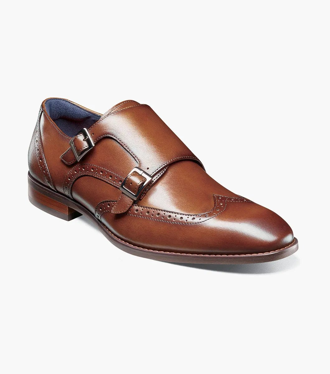 The Stacy Adams - KARSON Wingtip Double Monk Strap in cognac, model number 25570-221, is a shoe crafted with brown leather and features wingtip decorative perforations along with two side buckles, complemented by a RedZone footbed for exceptional comfort.