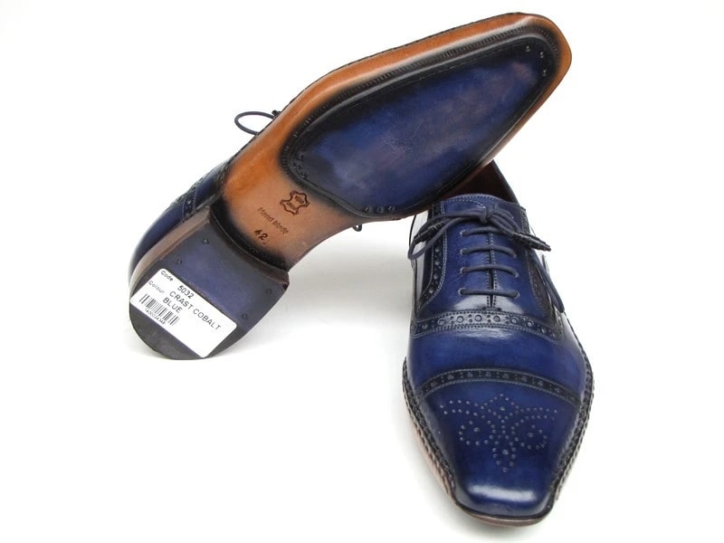 The Paul Parkman Captoe Navy Blue Hand Painted Oxfords - 5032-NAVY from Paul Parkman are a pair of men's handmade navy blue leather dress shoes. They feature decorative stitching, brown soles, laces, and a polished finish. These elegant oxfords exhibit the artistry of hand-painted leather for a sophisticated touch.