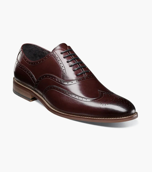 A Stacy Adams DUNBAR Wingtip Oxford, available in burgundy and identified as model 25064-601, is crafted from high-quality leather. It features classic brogue detailing with a lace-up design, enhanced with Memory Foam for added comfort.