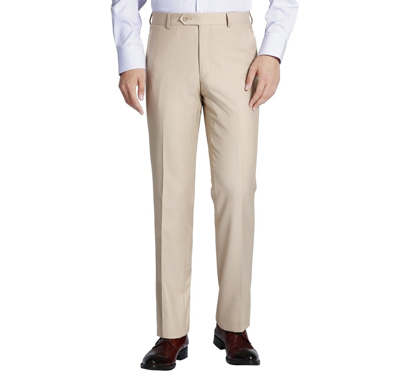 A man in Renoir's Alessandro Vitello beige classic fit flat front pants stands against a white background, paired with a light blue dress shirt and brown shoes.