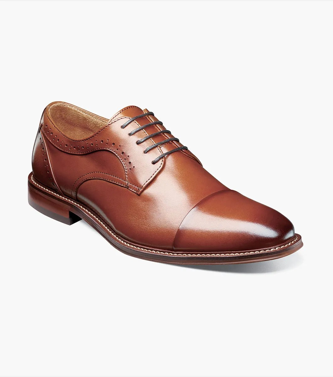 The Stacy Adams MADDOX Cap Toe Oxford in Cognac boasts a burnished leather finish, enhanced with a stylish cap toe and decorative perforations on the sides.