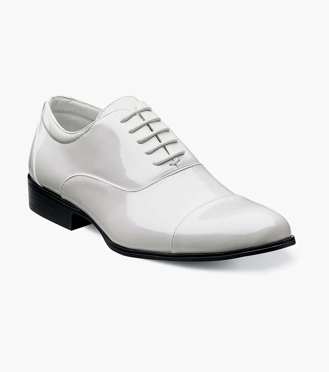 The Stacy Adams GALA Cap Toe Oxford in white patent leather, product number 24998-122, showcases a sleek cap toe design with black laces and a black sole, viewable from the side.