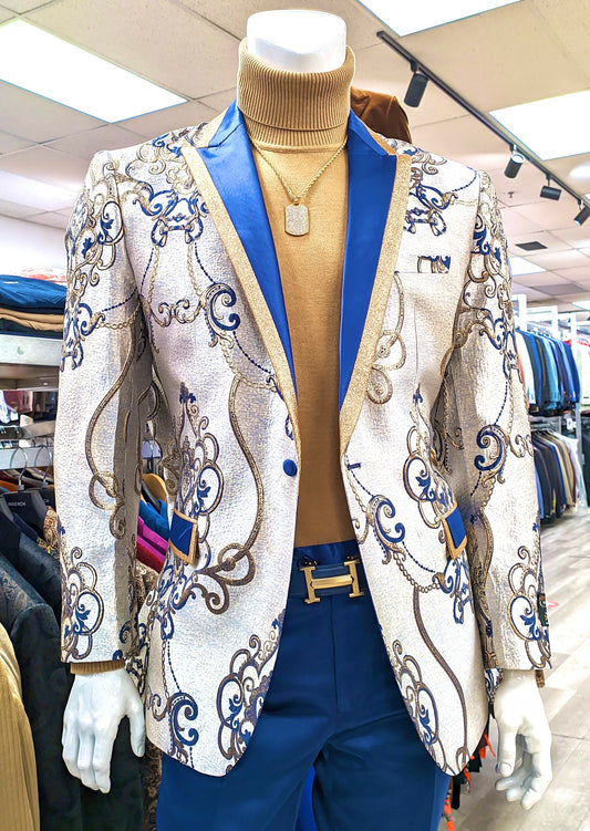 Displayed in a brightly lit store, the mannequin is outfitted in the INSOMNIA Super Slim Blazer 1 by Insomnia, featuring a striking blue and gold pattern, paired with a tan turtleneck and blue pants accented with a decorative belt.