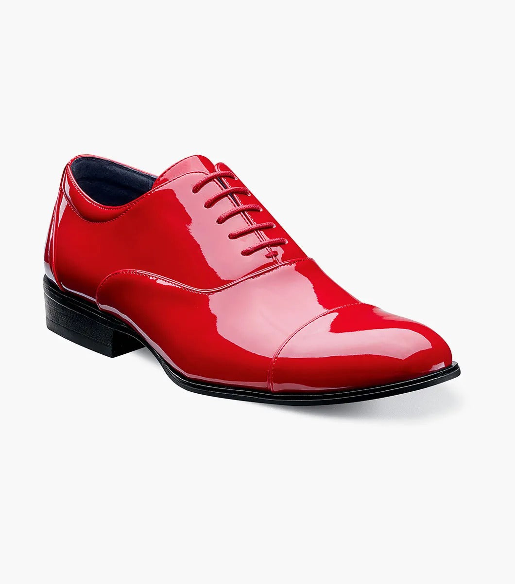 A solitary Stacy Adams GALA Cap Toe Oxford, product number 24998-600, made of shiny red patent leather with black soles and a closed lacing system featuring a memory foam insole, is displayed against a plain white background.