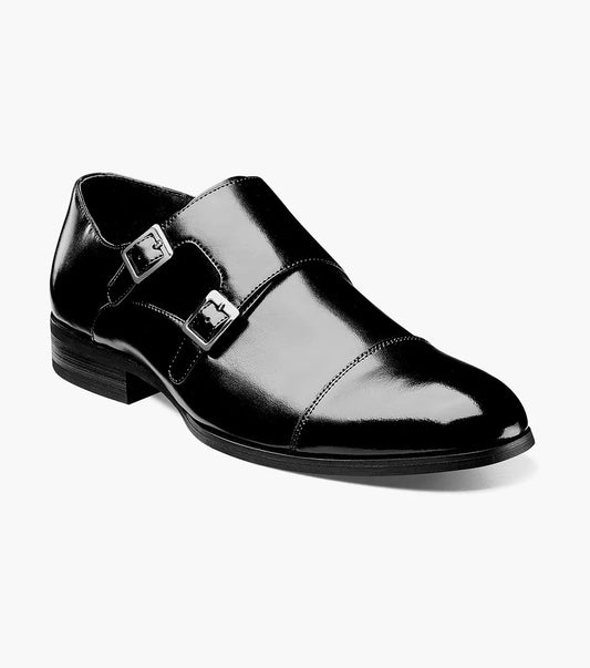 The Stacy Adams GORDON Cap Toe Monk Strap in black features a sleek cap toe design with a shiny leather upper, adorned with two silver buckles and a low heel.