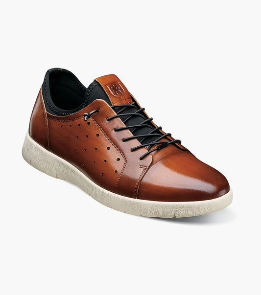 Introducing the Stacy Adams - HALDEN Lace Up Sneaker in Cognac, model 25382-221, featuring a brown leather upper with black laces and a white sole. It includes small perforations on the side for style and breathability, along with a cushioned footbed to ensure extra comfort.